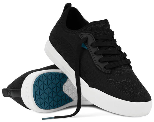A pair of black knit sneakers with black laces, a thick white midsole, and a blue patterned tread on the outsole.