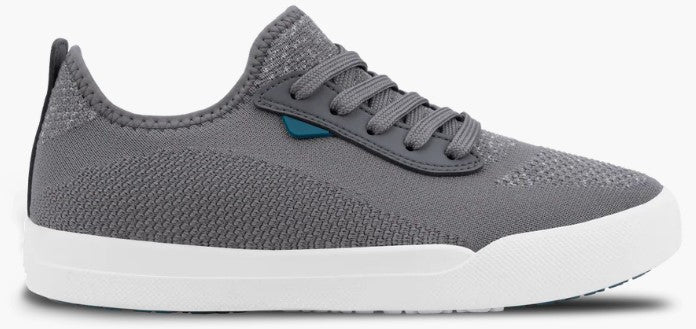 A gray knit sneaker with a white rubber sole, laces, and a small teal tab on the side.