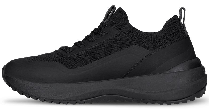 A sleek, monochromatic black sneaker shown from the side profile, featuring a knitted mesh upper with tonal synthetic overlays, a lace-up front, a cushioned thick midsole, and a ridged outsole.