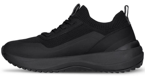 A side view of a black, minimalist slip-on sneaker with a knit upper, lace-up design, and a thick, chunky rubber sole.