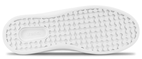 A close-up of a white shoe sole with a textured pattern of small, rounded bumps and the word vessi embossed in the center.