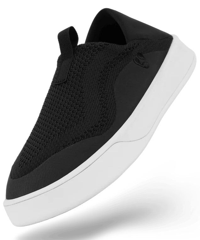 A slip-on sneaker featuring a black knit upper with a pull tab on the tongue and a thick, white rubber sole.