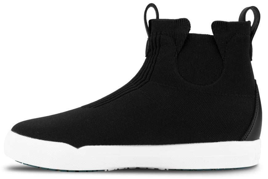 A black slip-on ankle boot with a high-top knit upper, a thick white rubber sole, and two small pull tabs at the back.
