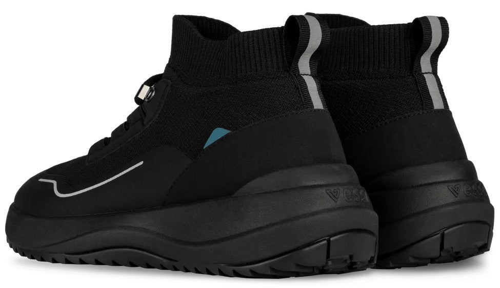 A pair of black, high-top, slip-on sneaker boots with a thick, textured black rubber sole, a pull tab with a grey reflective stripe at the heel, and a small blue triangular detail on the side.