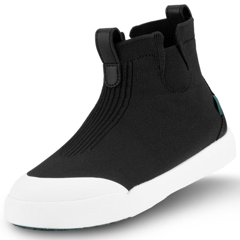 A black slip-on ankle sneaker with a ribbed knit upper, a black leather pull tab, and a white rubber toe cap and sole.
