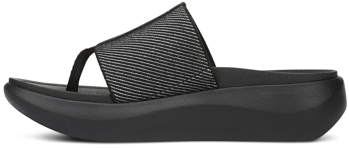 A black sandal with a toe post and a thick sole.