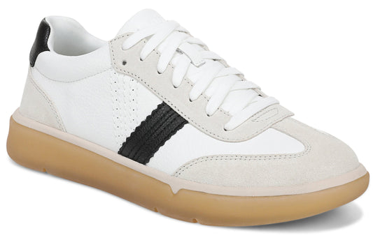 A low-top sneaker featuring a white leather upper, light gray suede toe and lace panel overlays, a prominent black textured side stripe, a black heel tab, white laces, and a thick, gum-colored rubber outsole.