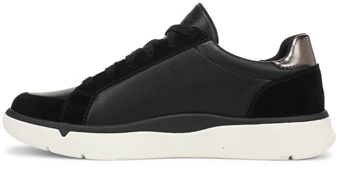 A side profile view of a black casual sneaker featuring a mix of smooth and suede-like textures, black laces, a metallic dark grey heel accent, and a thick white rubber sole.