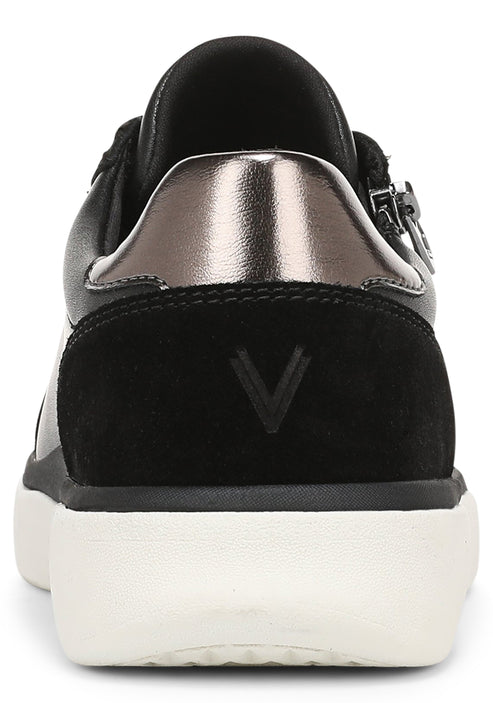 A back view of a black sneaker featuring a metallic silver heel tab, a black suede heel panel embossed with a V logo, and a thick white rubber sole.