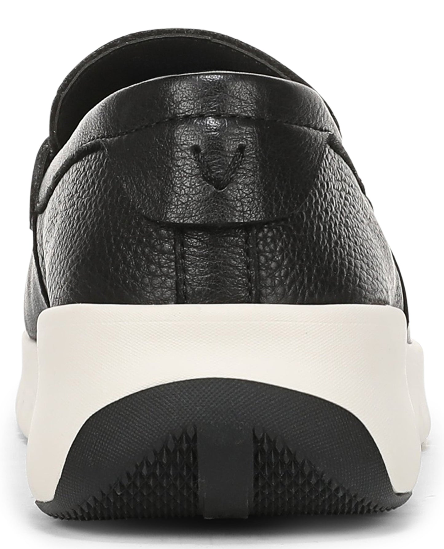A close-up view of the back heel of a black textured leather slip-on shoe, featuring a thick, white cushioned midsole and a black, treaded rubber outsole with a subtle brand logo embossed on the leather heel counter.