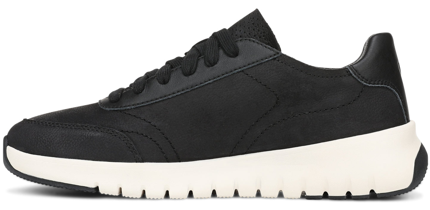 A minimalist, side-view of a black low-top sneaker with a black textured upper, black laces, and a thick, white, grooved rubber sole.