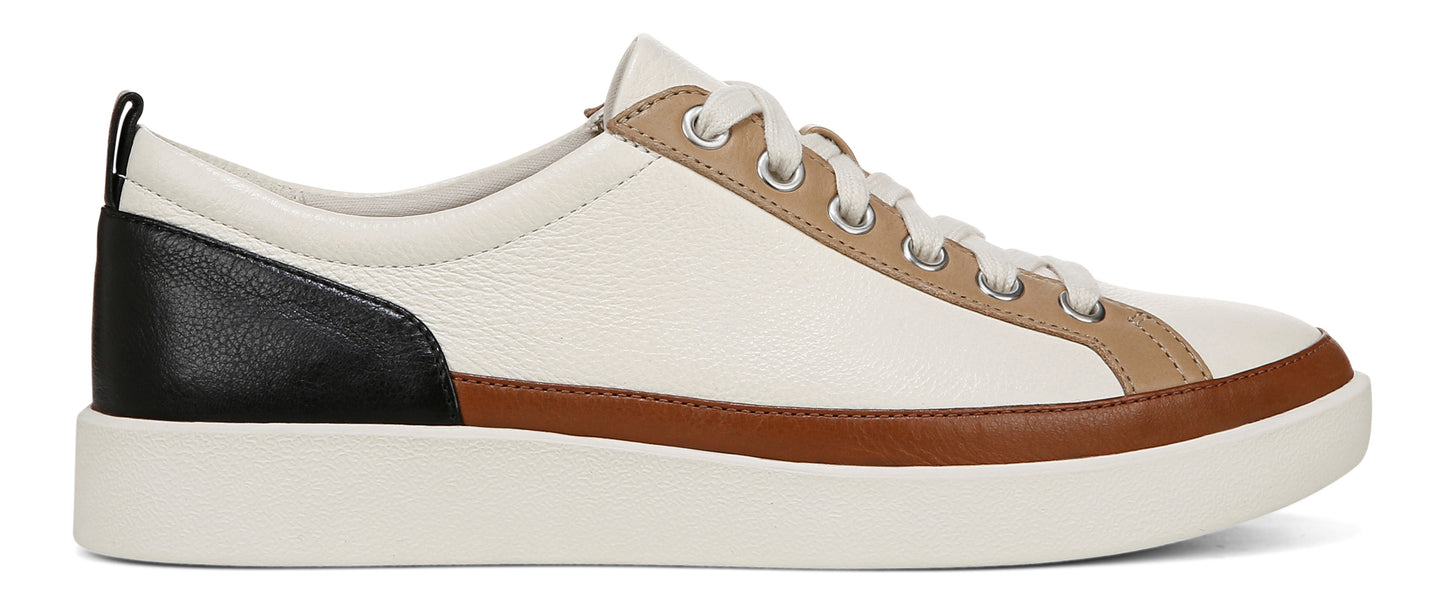 A low-top, laced shoe with a thick white sole, featuring black, brown, and beige accents.