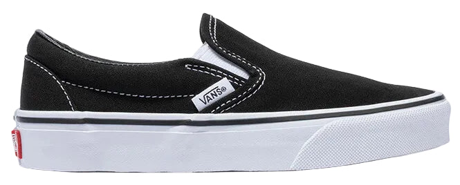 A black slip-on canvas shoe with white stitching, white rubber sidewalls with a thin black stripe, and a small white tag with black lettering reading VANS on the outer side.
