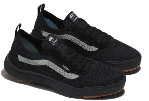 Pair of knit black sneakers with light gray side stripe, and brown sole.