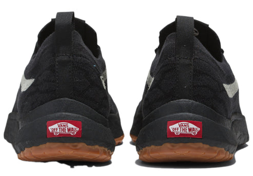 A pair of black low-top sneakers with a silver stripe on the side and a red label with the text "OFF THE WALL" on the heel.
