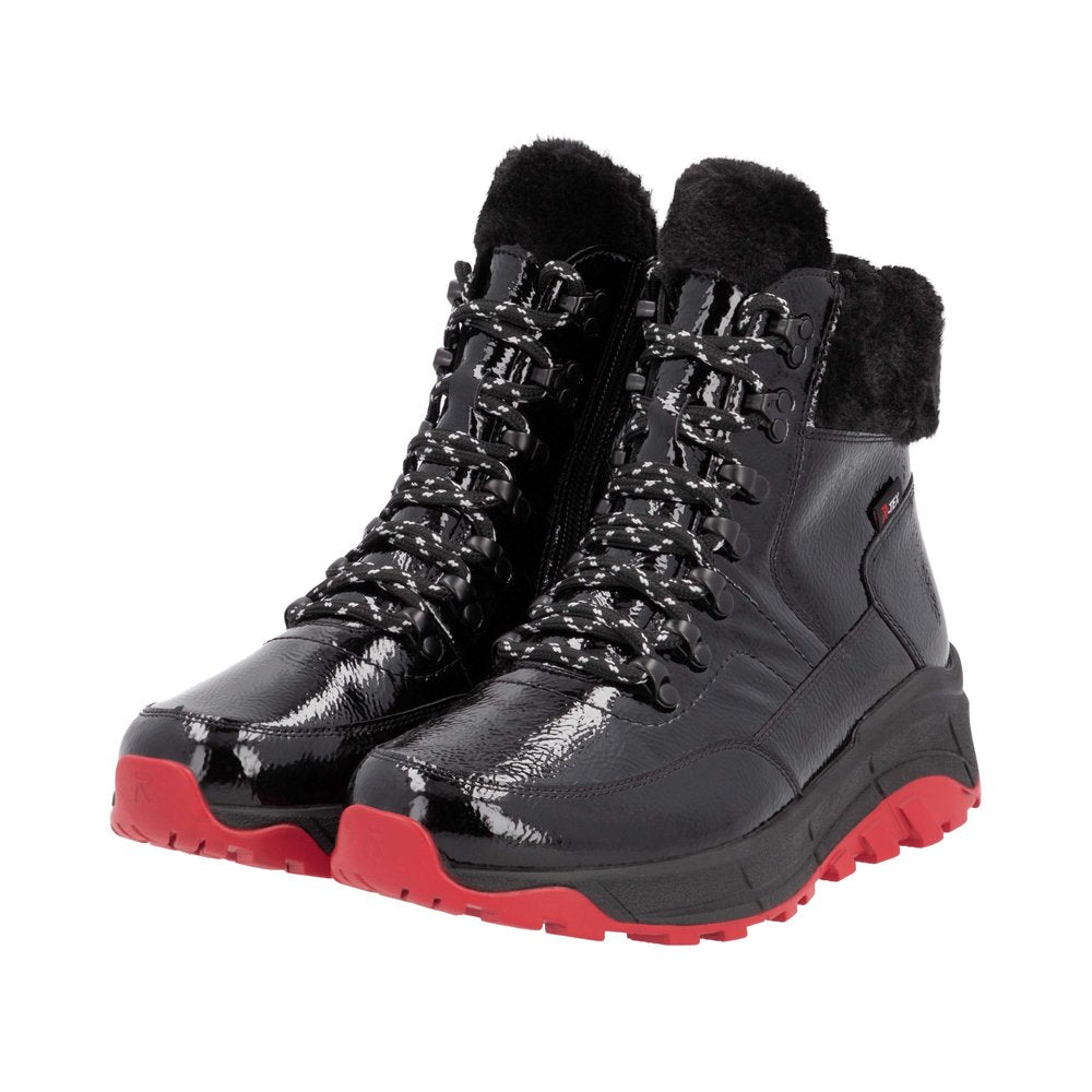 A pair of black patent leather high top boots with black laces and red soles.