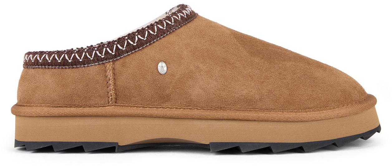 A brown slipper with a treaded sole and decorative stitching.