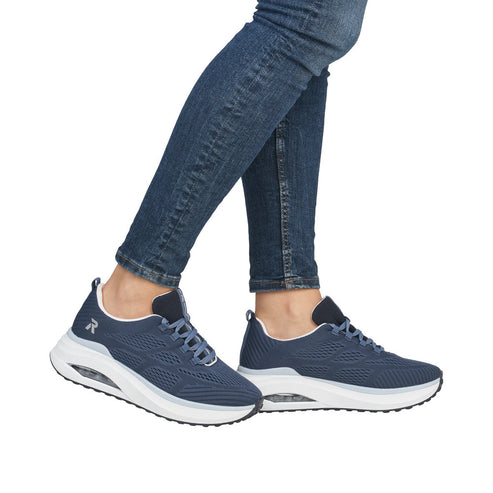 Person wearing blue denim and blue sneakers with white soles, laces, and an 'R' on the side.