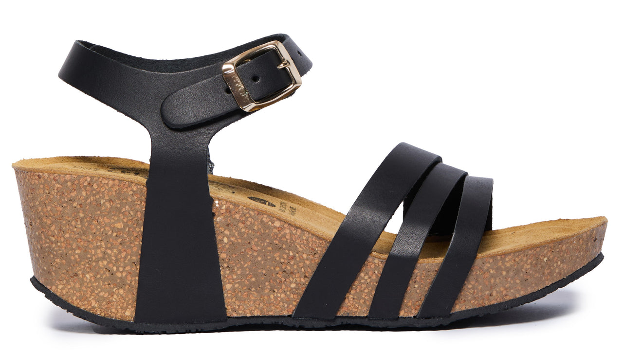 Black sandal with ankle strap and stacked cork wedge heel.