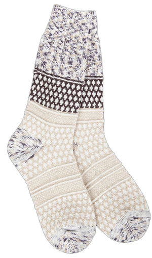 A pair of crew socks patterned with cream-colored stripes and knit designs in cream, brown, gray, and white.