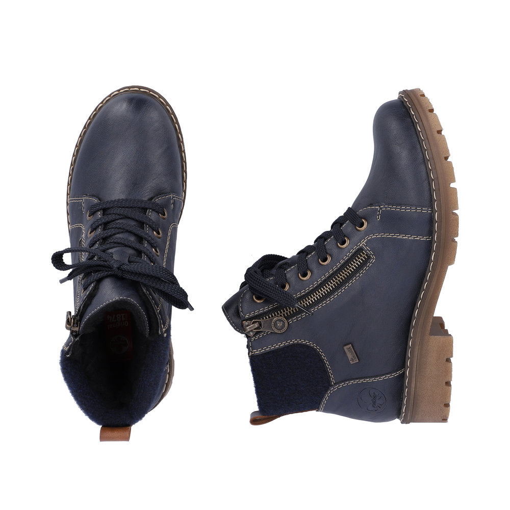 Two navy blue ankle boots, one seen from the toe and one on its side, with laces and side zippers, on a lug sole.