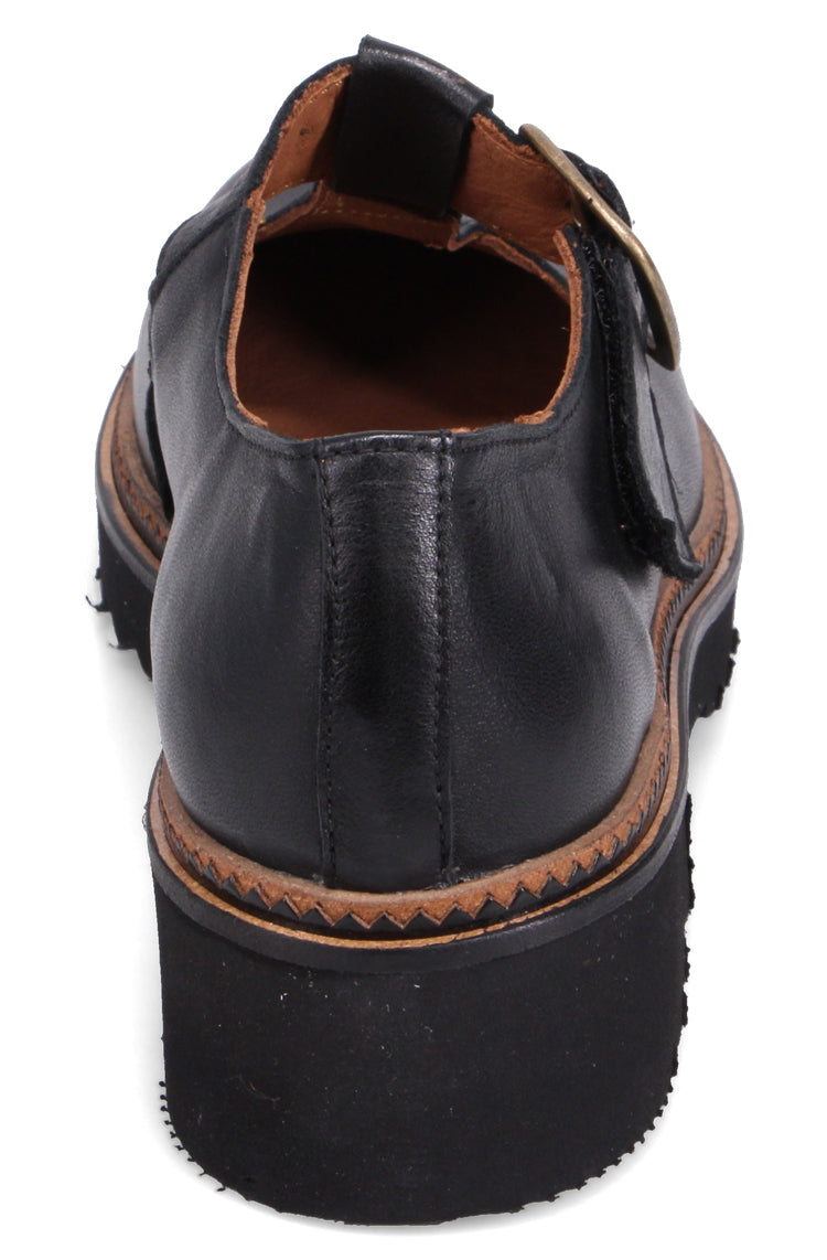 Black leather Mary Jane shoe with a chunky platform sole and buckle strap.