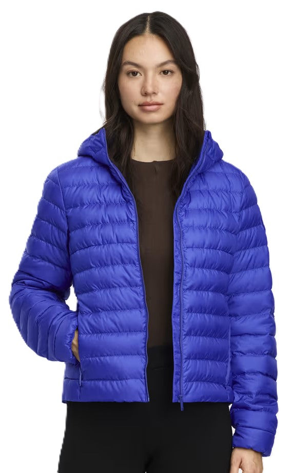 A woman is wearing a blue, hooded puffer jacket.