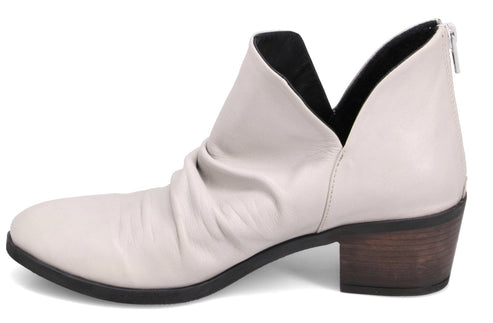 Low-heeled, light-colored ankle boot with a v-shaped opening in the back.