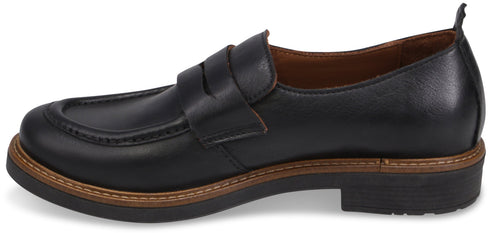 A black leather penny loafer shoe featuring a classic apron toe, a sturdy brown welt with decorative stitching, and a low, thick black heel.