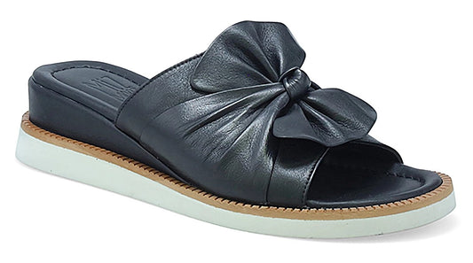 Black leather slide sandal with a bow on the upper and a white platform sole.