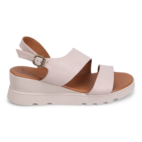 A women's light pink sandal with adjustable buckle strap and platform sole.