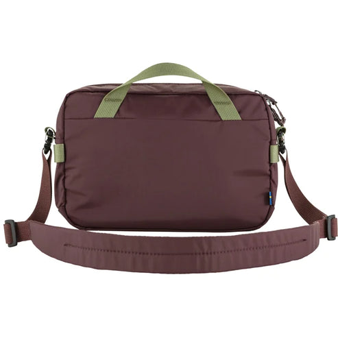 Brown bag with olive green handles and shoulder strap.