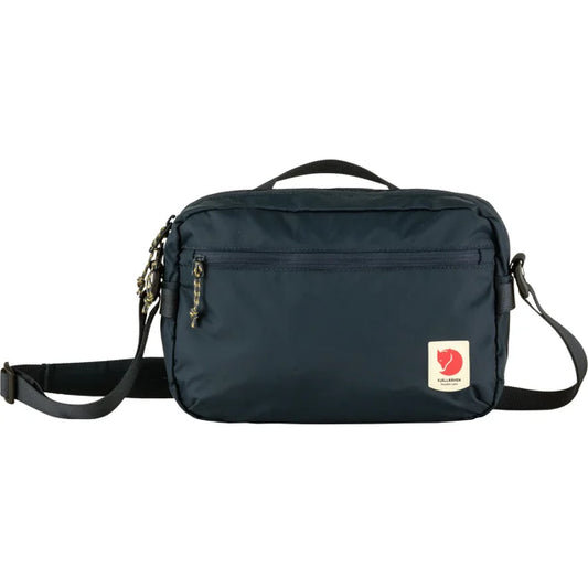 Dark blue messenger bag with shoulder strap, top handle, front zipper pocket, and red and white logo.