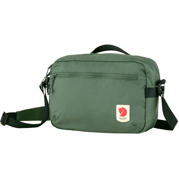 Green messenger bag with a red and white circular patch on the front.