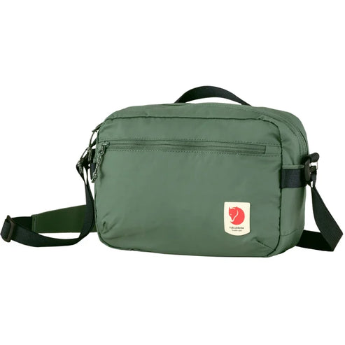 Green messenger bag with a red and white circular patch on the front.