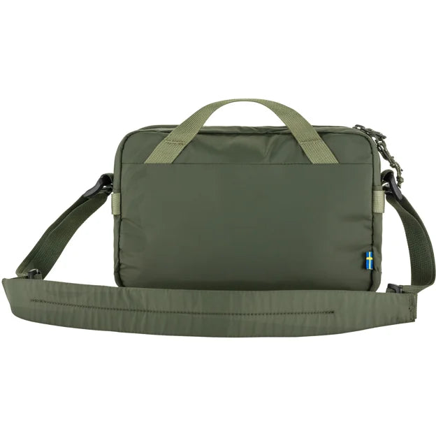 Olive green padded rectangular shoulder bag with top handle and adjustable shoulder strap, displaying a small Swedish flag tag.
