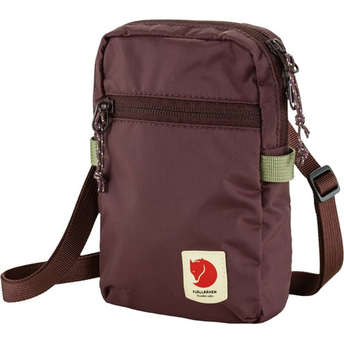 Small maroon Fjallraven shoulder bag with adjustable brown strap, zipper compartments and logo.