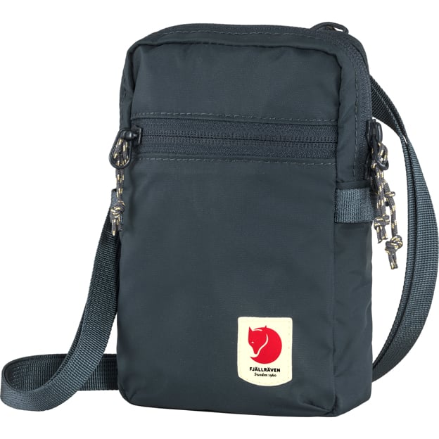 A small dark blue crossbody bag with a front zipper pocket and a square logo patch in the lower right corner with a red fox on a cream background.