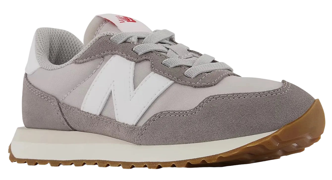 Low-top athletic shoe, gray suede panels on a light gray nylon base, white N logo, gum sole.