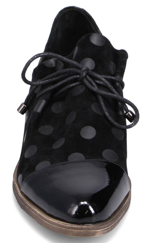 Black leather shoe with a rounded glossy toe cap, laces and polka dots.