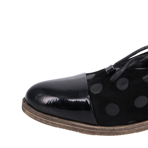 Close-up of a black dress shoe with a shiny black cap toe and polka dot design.