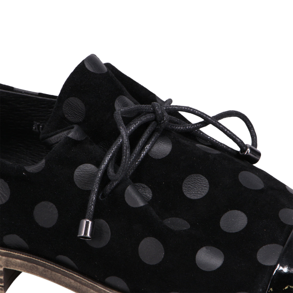 Black suede shoe with black polka dots and black laces.