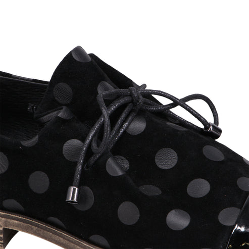 Black suede shoe with black polka dots and black laces.
