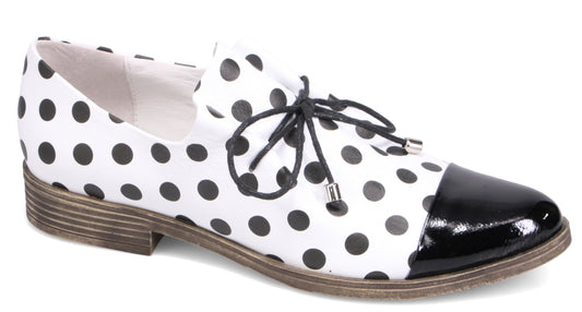 White and black polka dot dress shoe with black patent leather toe and lace-up closure.