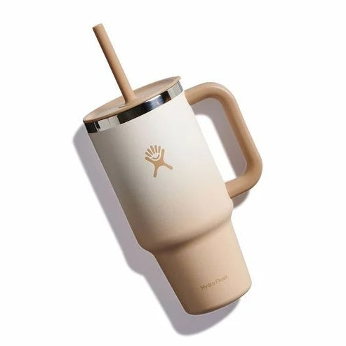 Tan stainless steel tumbler with a straw, handle, and a logo.