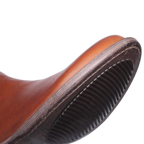 Close-up of the sole of a brown leather boot.