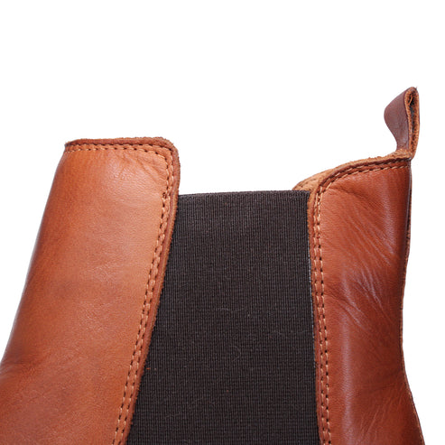 Close up view of a tan leather boot showing the pull tab.