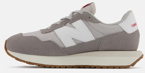 A running shoe with a white "N" on the side, with a tan sole, and gray suede on the toe.
