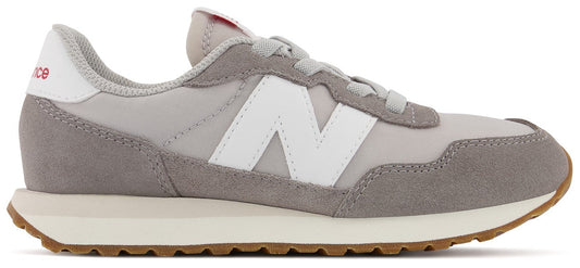 A gray and white sneaker with a brown sole.