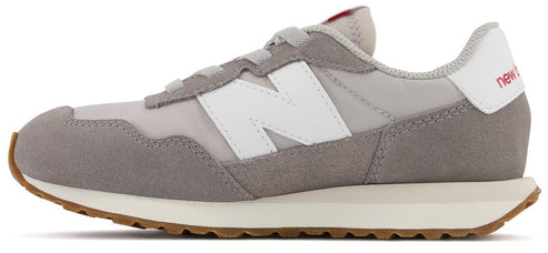 A gray and white sneaker with the brand name "new b" in red on the heel.